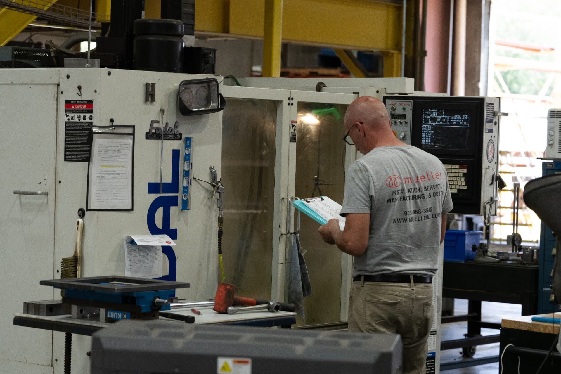 Mueller machinist setting up a CNC mill in the Sherman, TX shop